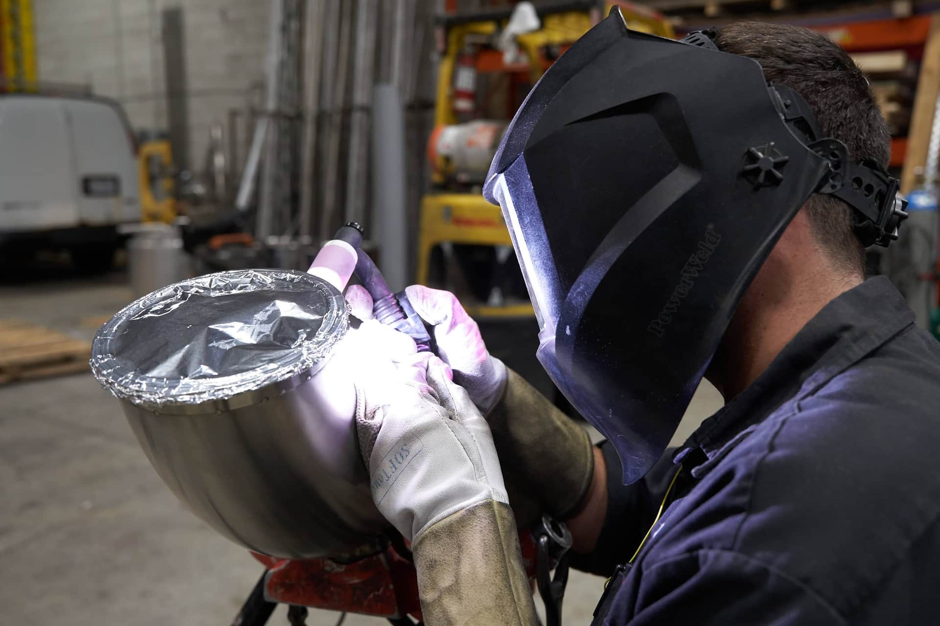 A fabricator completing a sanitary stainless weld